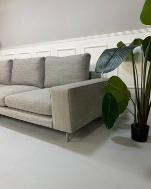 Refurbished graues Minotti Sherman Designer Stoff Sofa vor einer Wand, stilvoll und modern eingerichtet.