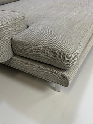 Refurbished graues Minotti Sherman Designer Stoff Sofa vor einer Wand, stilvoll und modern eingerichtet.