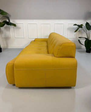 Refurbished gelbes Roche Bobois Blogger Designer Leder Sofa vor einer Wand, stilvoll und modern eingerichtet.