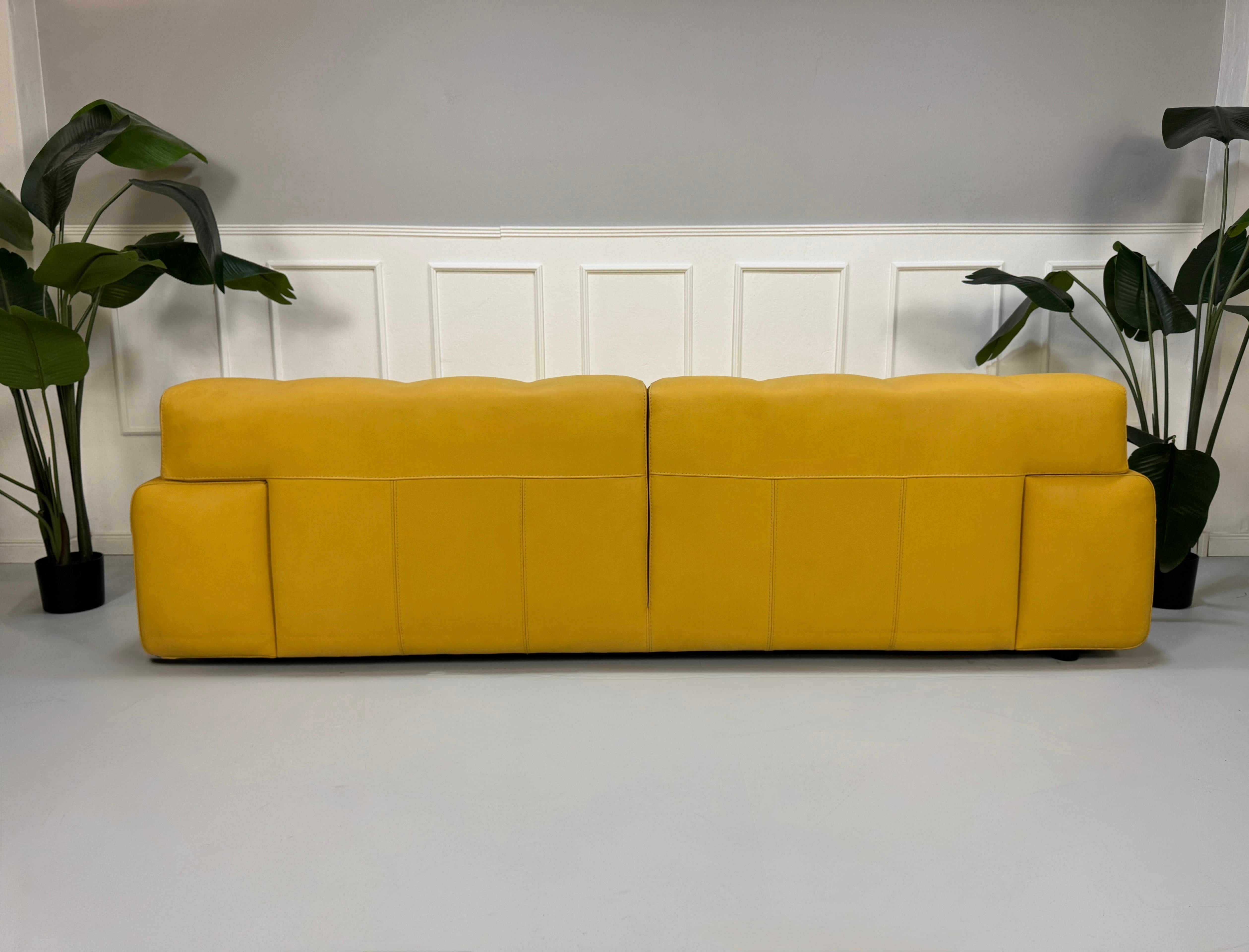 Refurbished gelbes Roche Bobois Blogger Designer Leder Sofa vor einer Wand, stilvoll und modern eingerichtet.