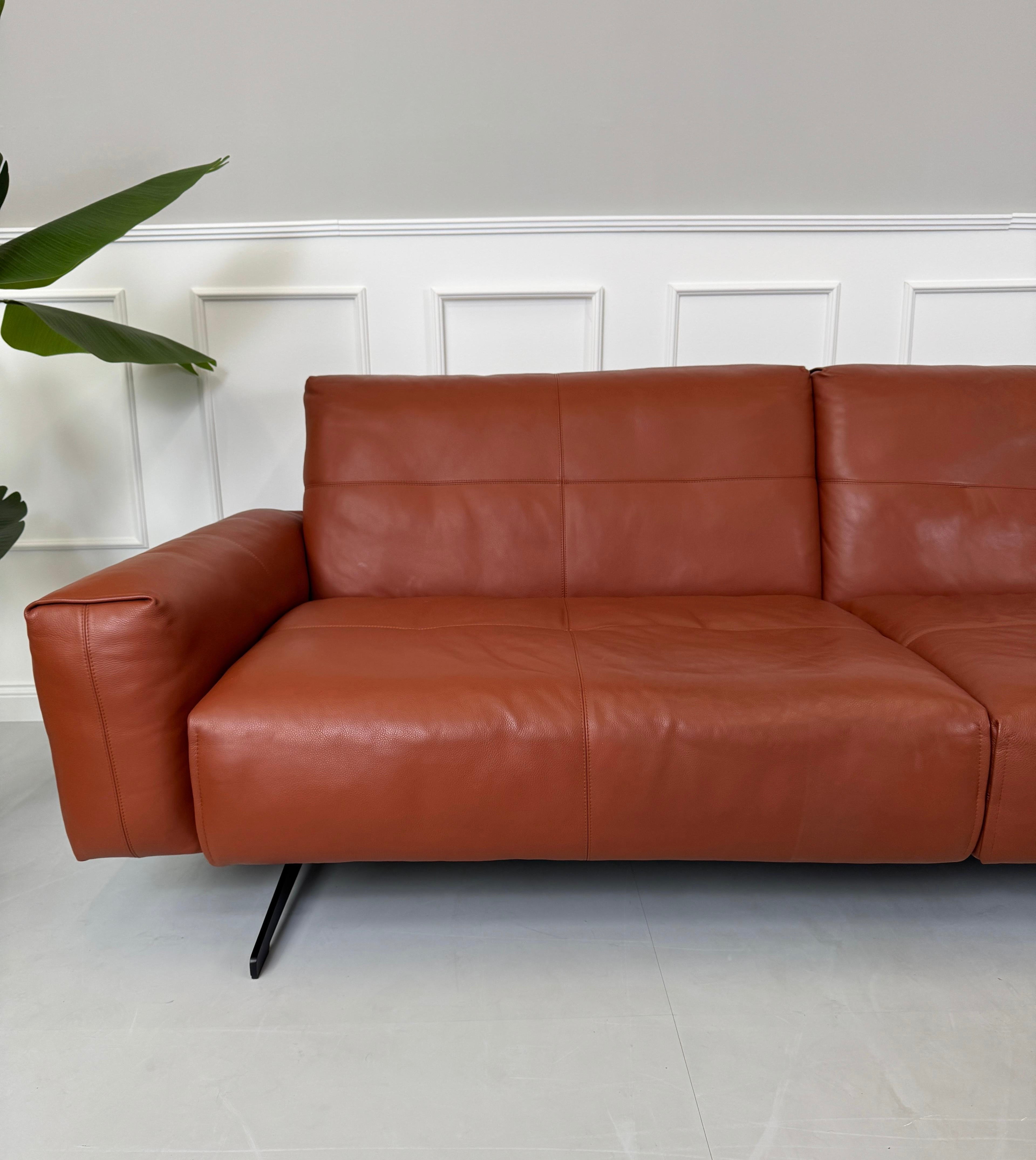 Erneuertes braunes Rolf Benz 50 Designer Leder Sofa vor einer Wand, stilvoll und modern eingerichtet.