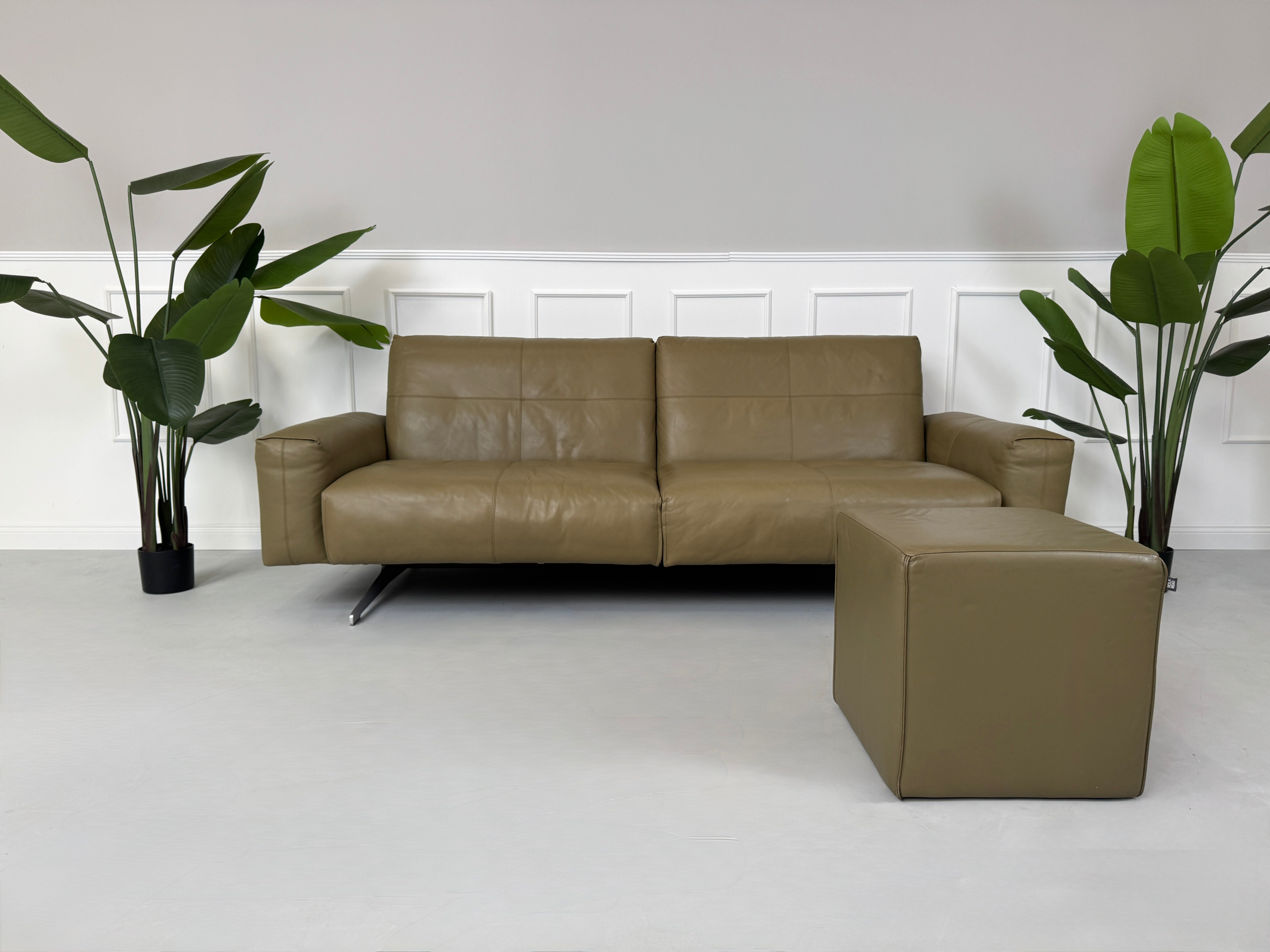 Erneuertes Rolf Benz 50 mit Hocker Designer Leder Sofa vor einer Wand, stilvoll und modern eingerichtet.