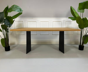 Gebrauchter Rolf Benz Holz Tisch vor einer Wand, stilvoll und modern eingerichtet.