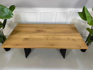 Gebrauchter Rolf Benz Holz Tisch vor einer Wand, stilvoll und modern eingerichtet.