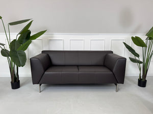Erneuertes braunes Rolf Benz Linea Designer Leder Sofa vor einer Wand, stilvoll und modern eingerichtet.