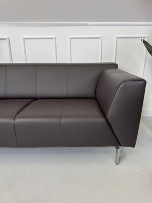Erneuertes braunes Rolf Benz Linea Designer Leder Sofa vor einer Wand, stilvoll und modern eingerichtet.