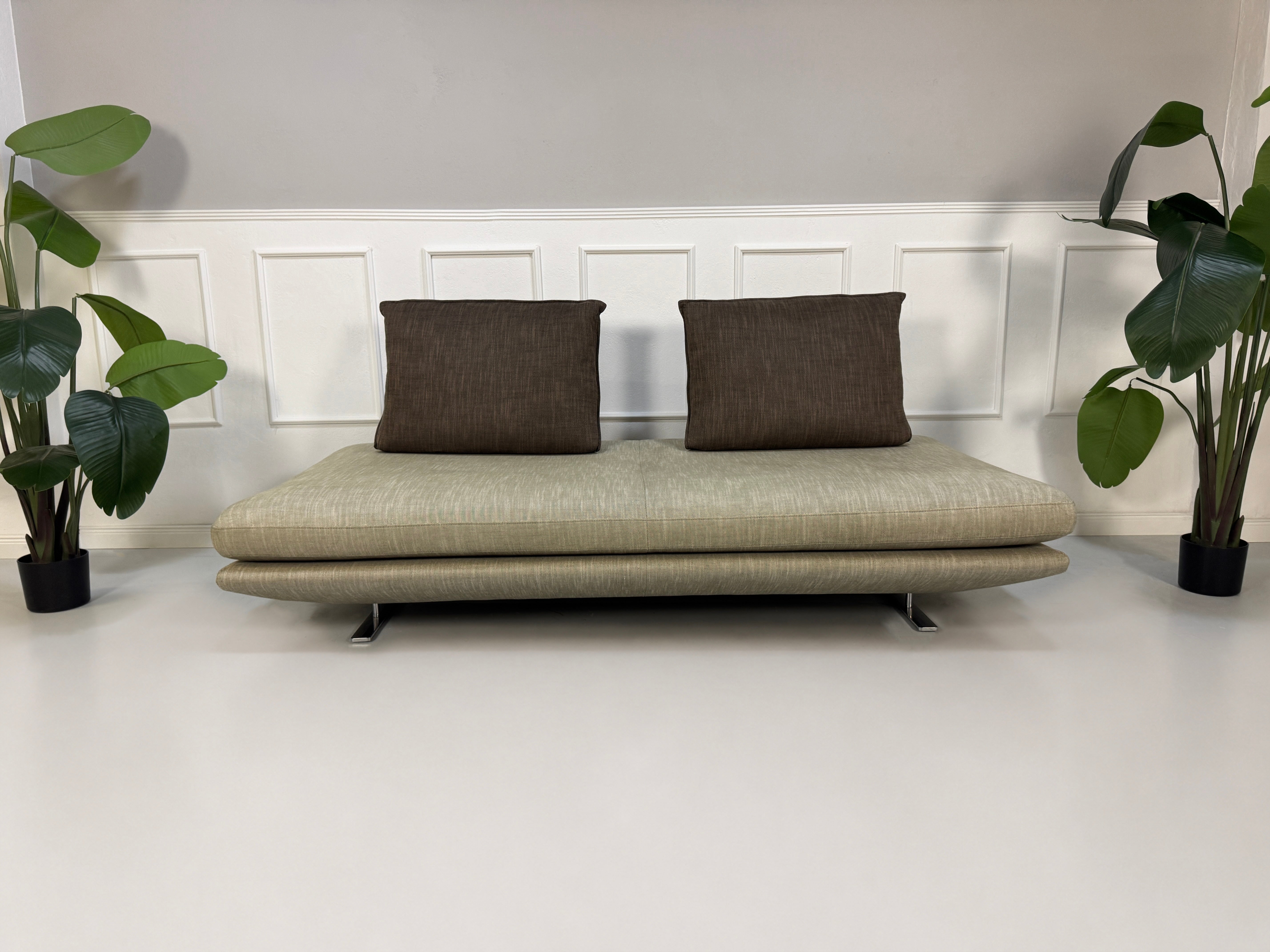 Gebrauchtes graues Ligne Roset Prado Designer Stoff Sofa vor einer Wand, stilvoll und modern eingerichtet.
