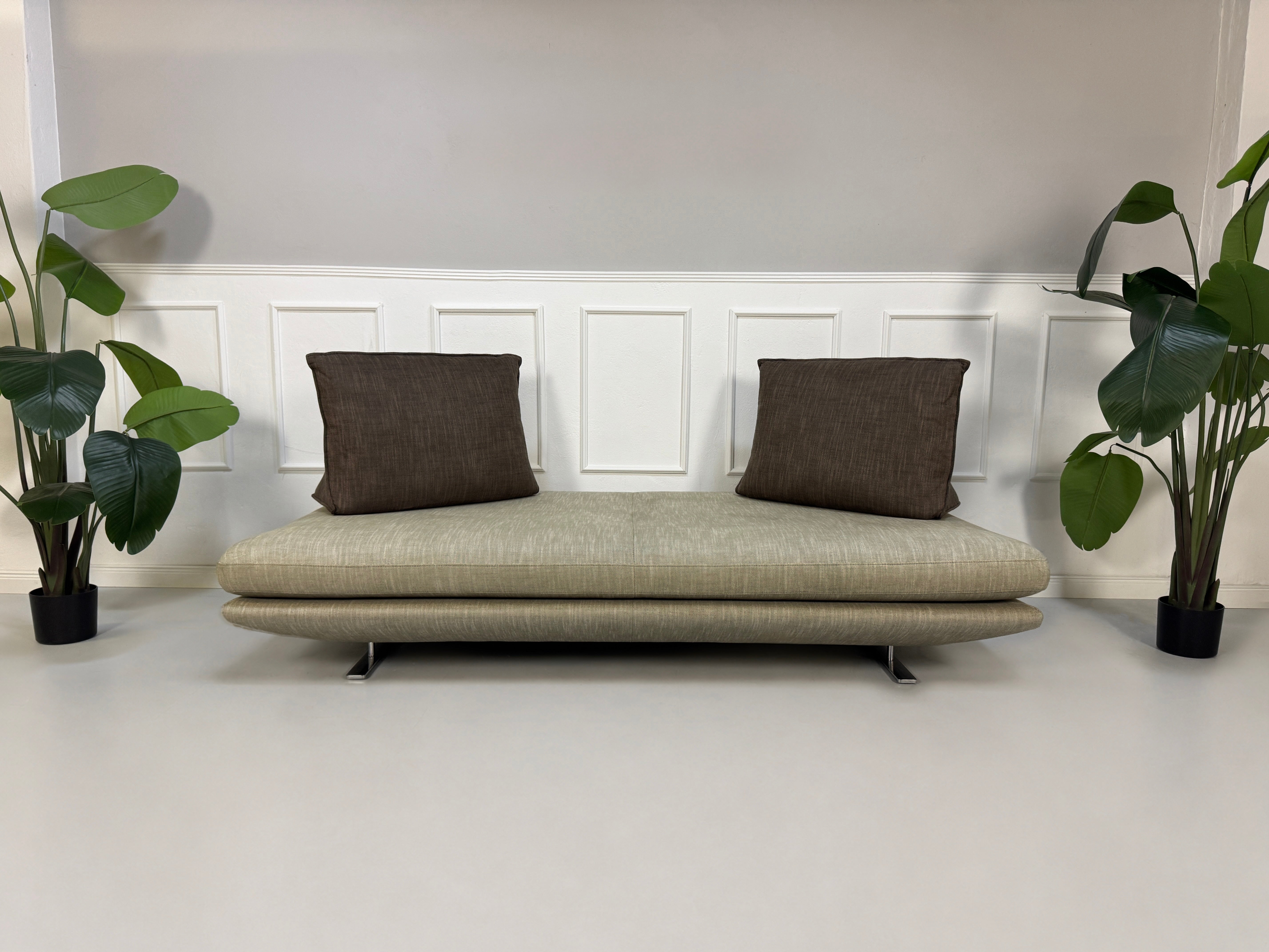 Gebrauchtes graues Ligne Roset Prado Designer Stoff Sofa vor einer Wand, stilvoll und modern eingerichtet.