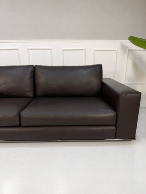 Gebrauchtes braunes Minotti Hamilton Designer Leder Sofa vor einer Wand, stilvoll und modern eingerichtet.