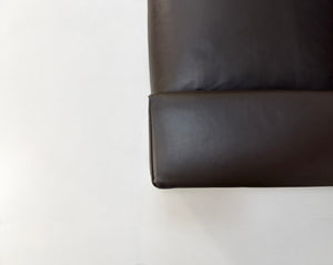 Gebrauchtes braunes Minotti Hamilton Designer Leder Sofa vor einer Wand, stilvoll und modern eingerichtet.
