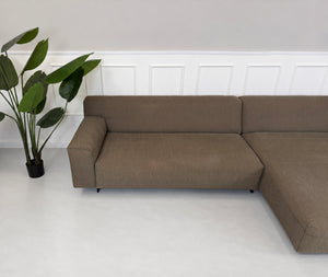 Gebrauchtes braunes Rolf Benz Grata Designer Stoff Ecksofa vor einer Wand, stilvoll und modern eingerichtet.