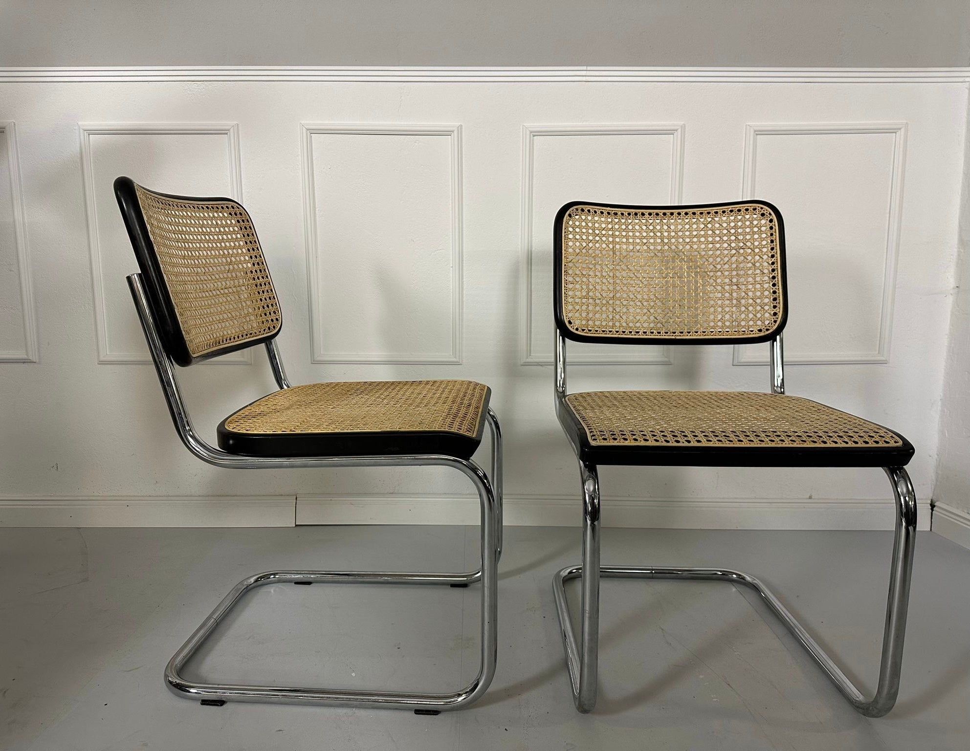 Gebrauchte Thonet S32 Freischwinger Stühle vor einer Wand, stilvoll und modern eingerichtet.