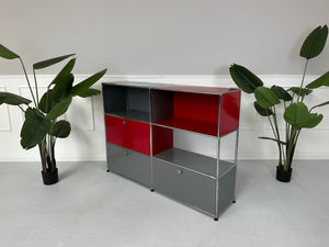 Gebrauchtes USM Haller Designer Regal in den Farben Rot und Grau vor einer Wand, stilvoll und modern eingerichtet.