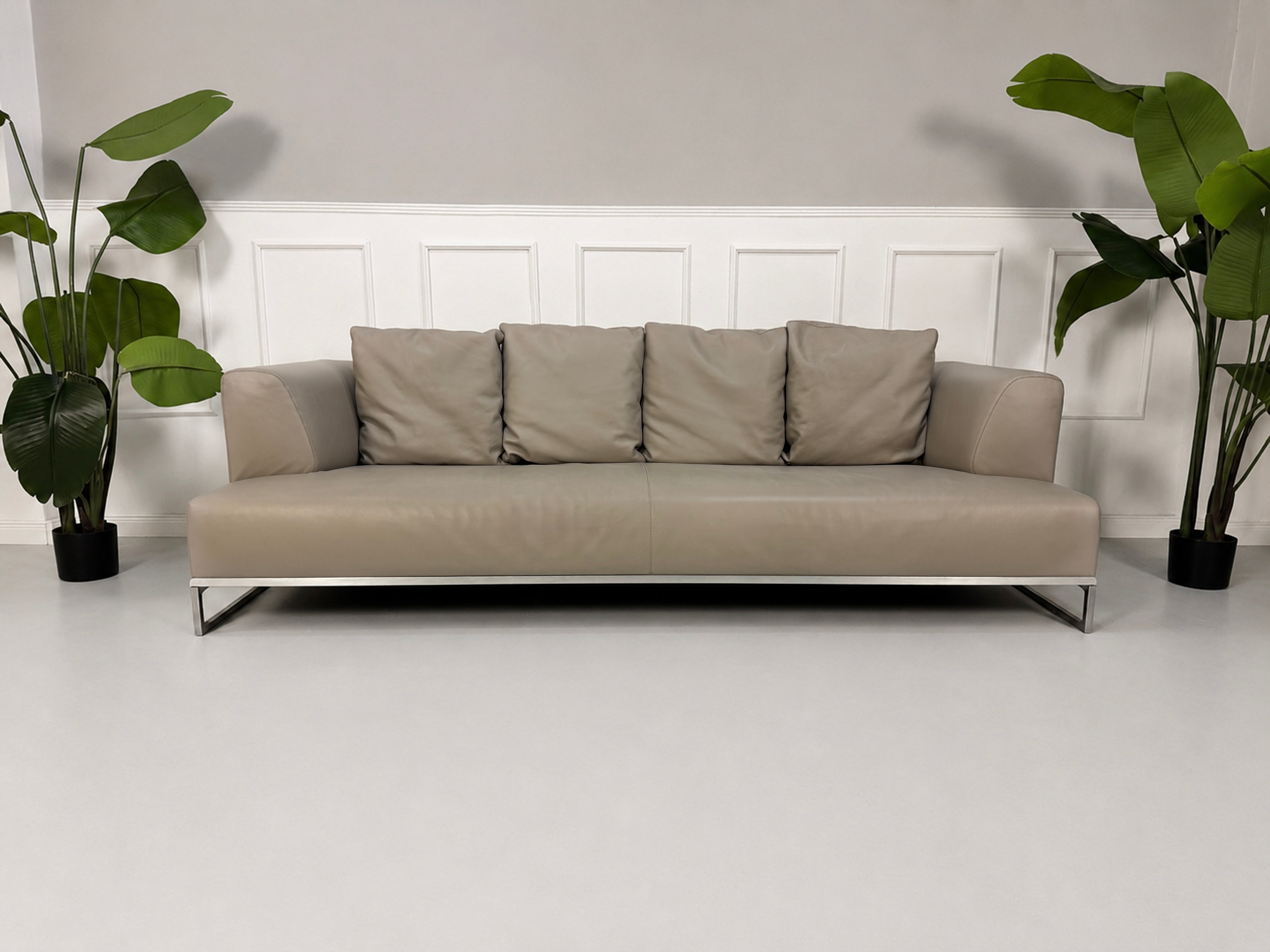 Gebrauchtes graues B&B Italia Solo Designer Leder Sofa vor einer Wand, stilvoll und modern eingerichtet.