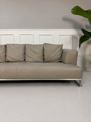 Gebrauchtes graues B&B Italia Solo Designer Leder Sofa vor einer Wand, stilvoll und modern eingerichtet.
