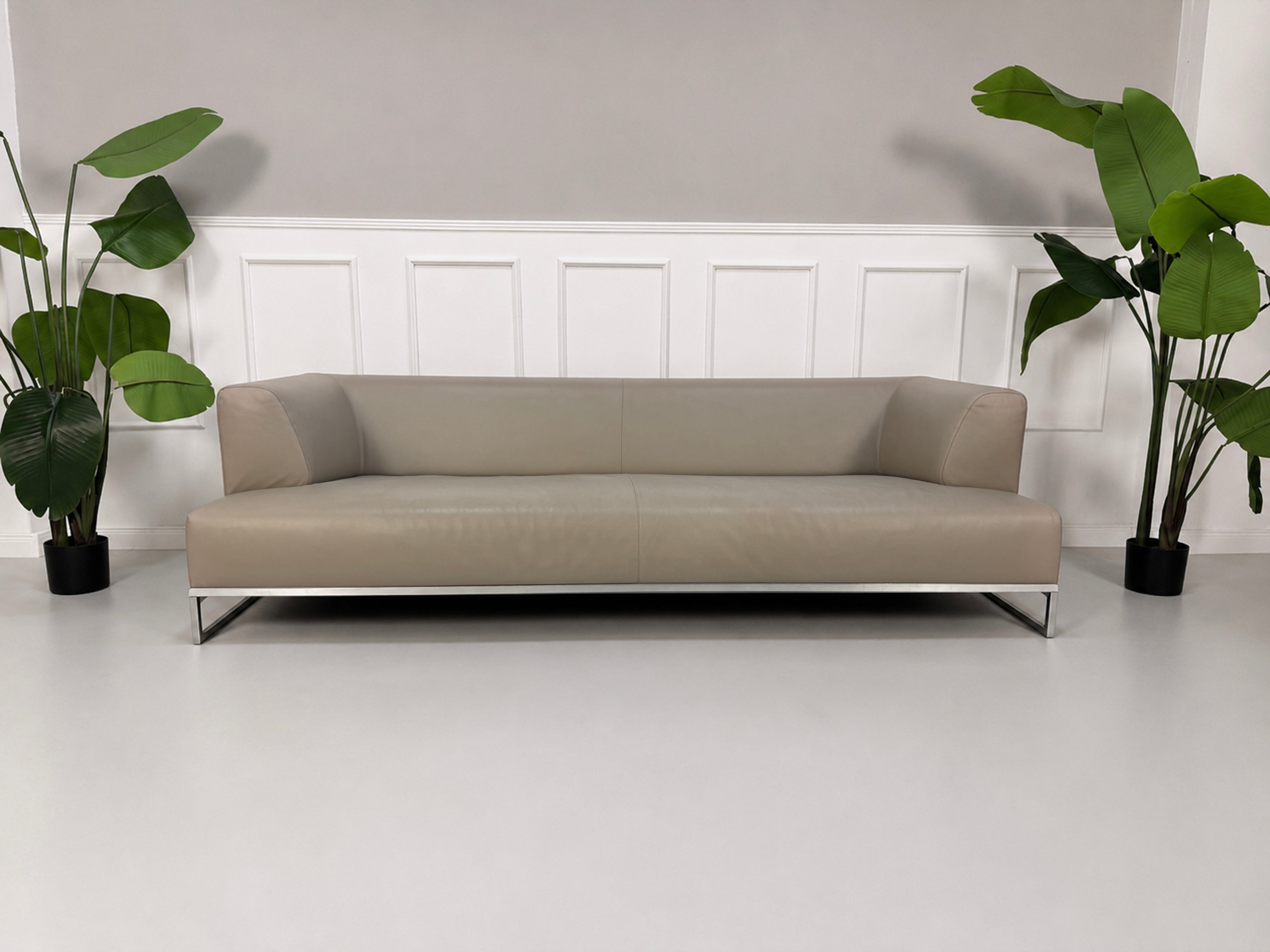 Gebrauchtes graues B&B Italia Solo Designer Leder Sofa vor einer Wand, stilvoll und modern eingerichtet.
