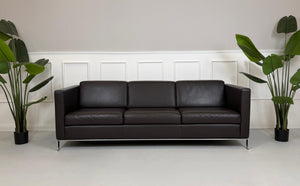 Gebrauchtes braunes Walter Knoll Foster Designer Leder Sofa vor einer Wand, stilvoll und modern eingerichtet.
