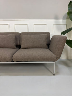 Gebrauchtes braunes Brühl Roro Designer Stoff Sofa vor einer Wand, stilvoll und modern eingerichtet.