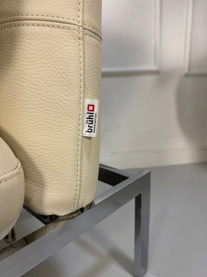 Gebrauchter beiger Brühl Roro Small Designer Leder Sessel vor einer Wand, stilvoll und modern eingerichtet.