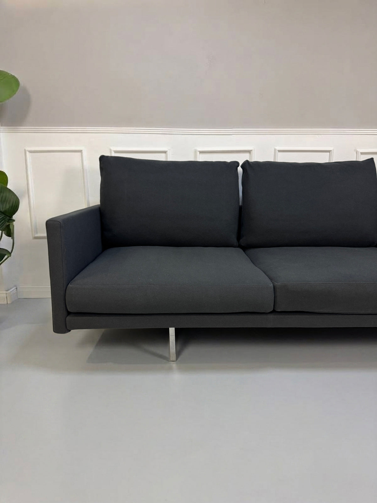 Gebrauchtes graues Cassina Toot Designer Stoff Sofa vor einer Wand, stilvoll und modern eingerichtet.