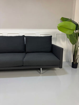 Gebrauchtes graues Cassina Toot Designer Stoff Sofa vor einer Wand, stilvoll und modern eingerichtet.