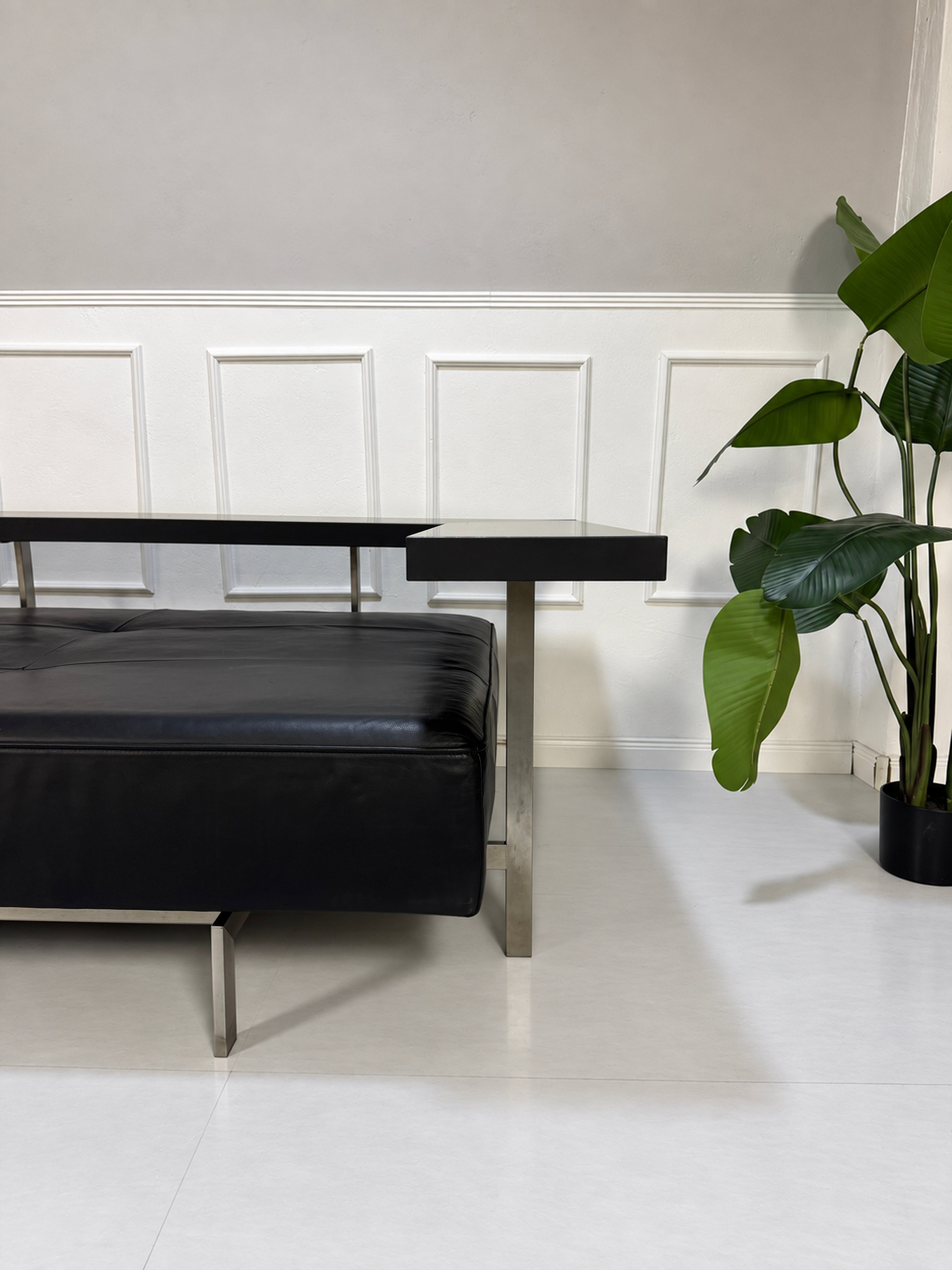 Gebrauchtes schwarzes Rolf Benz Dono Designer Leder Sofa vor einer Wand, stilvoll und modern eingerichtet.