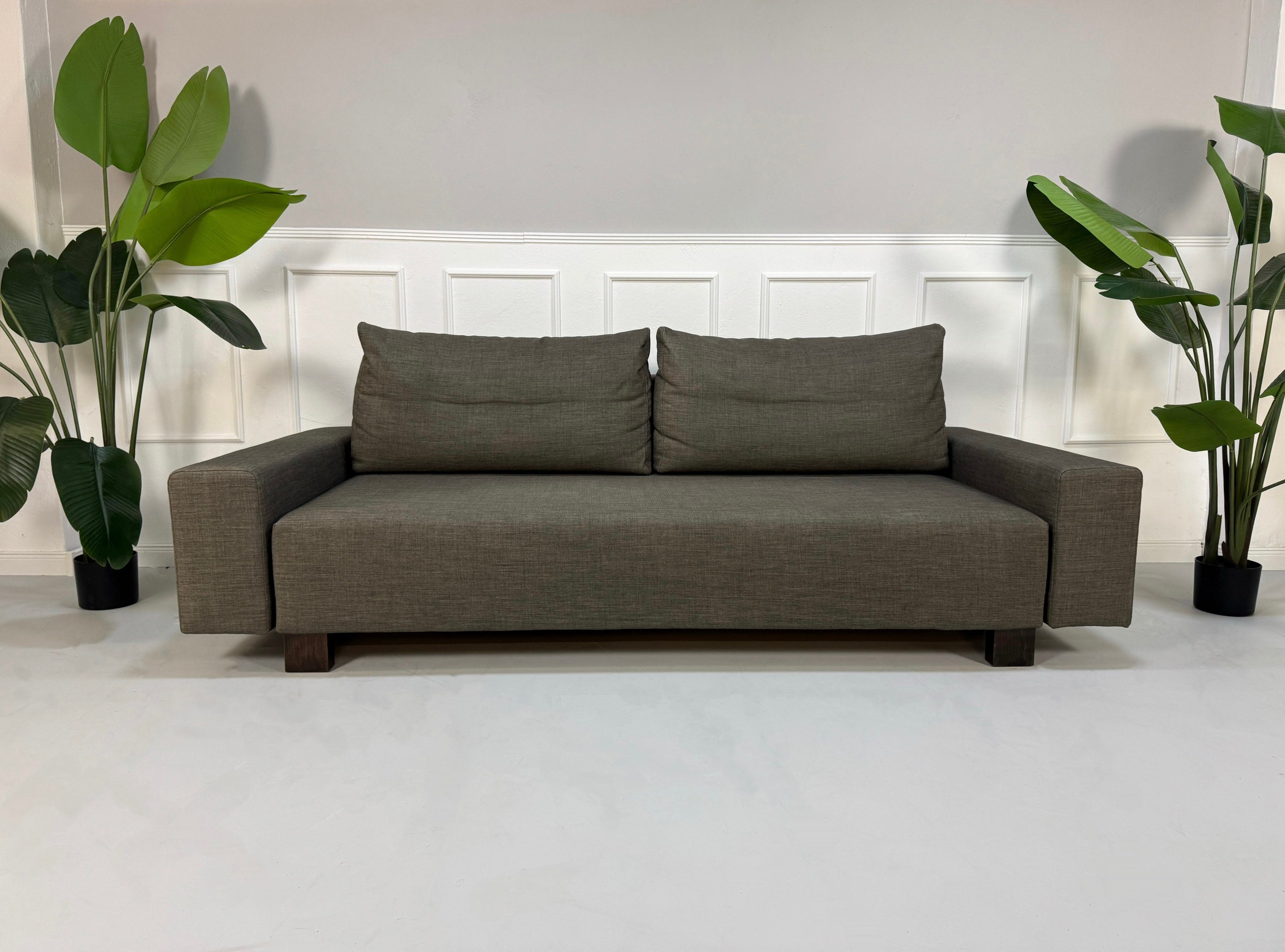 Gebrauchtes Signet Sofa in grau braunem Stoff vor einer Wand
