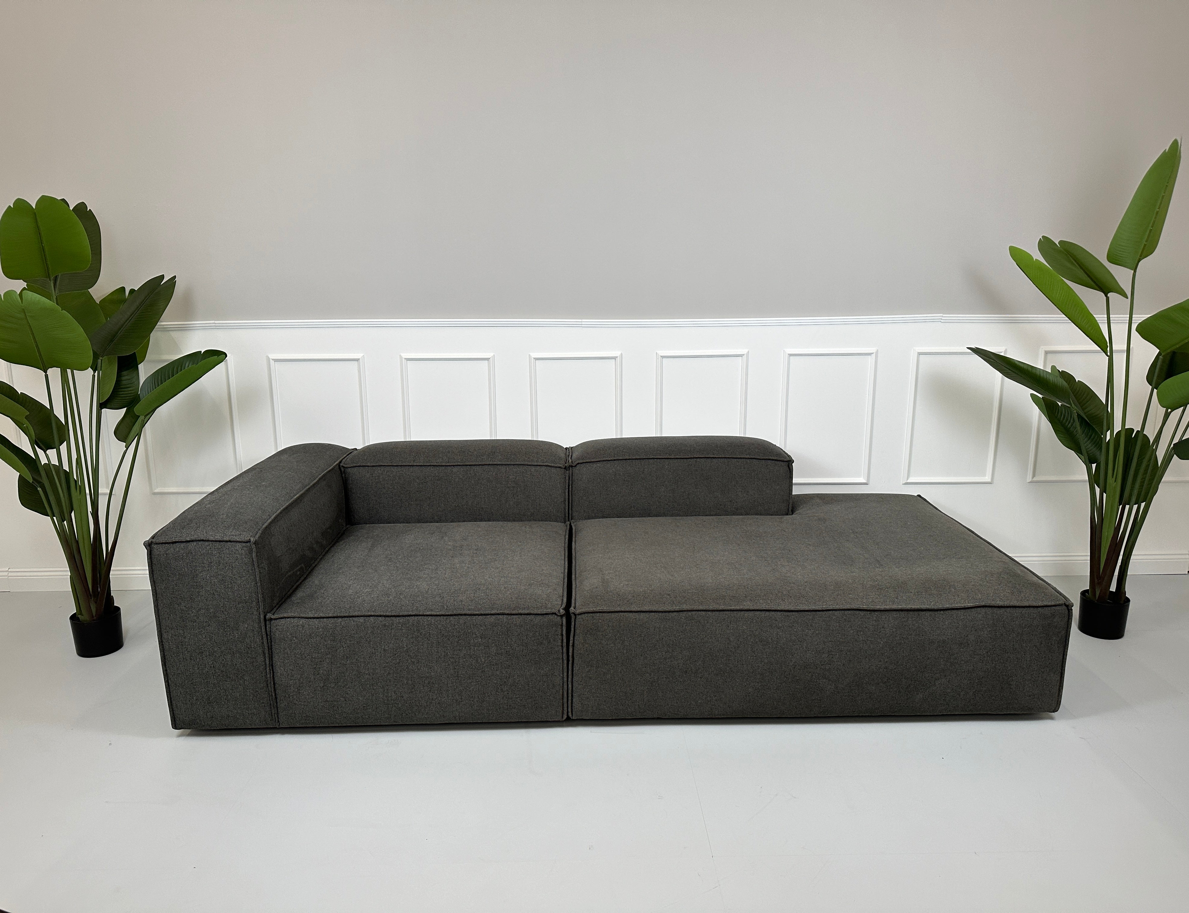 Gebrauchtes Westwing Designer Sofa vor einer Wand, stilvoll und modern eingerichtet.
