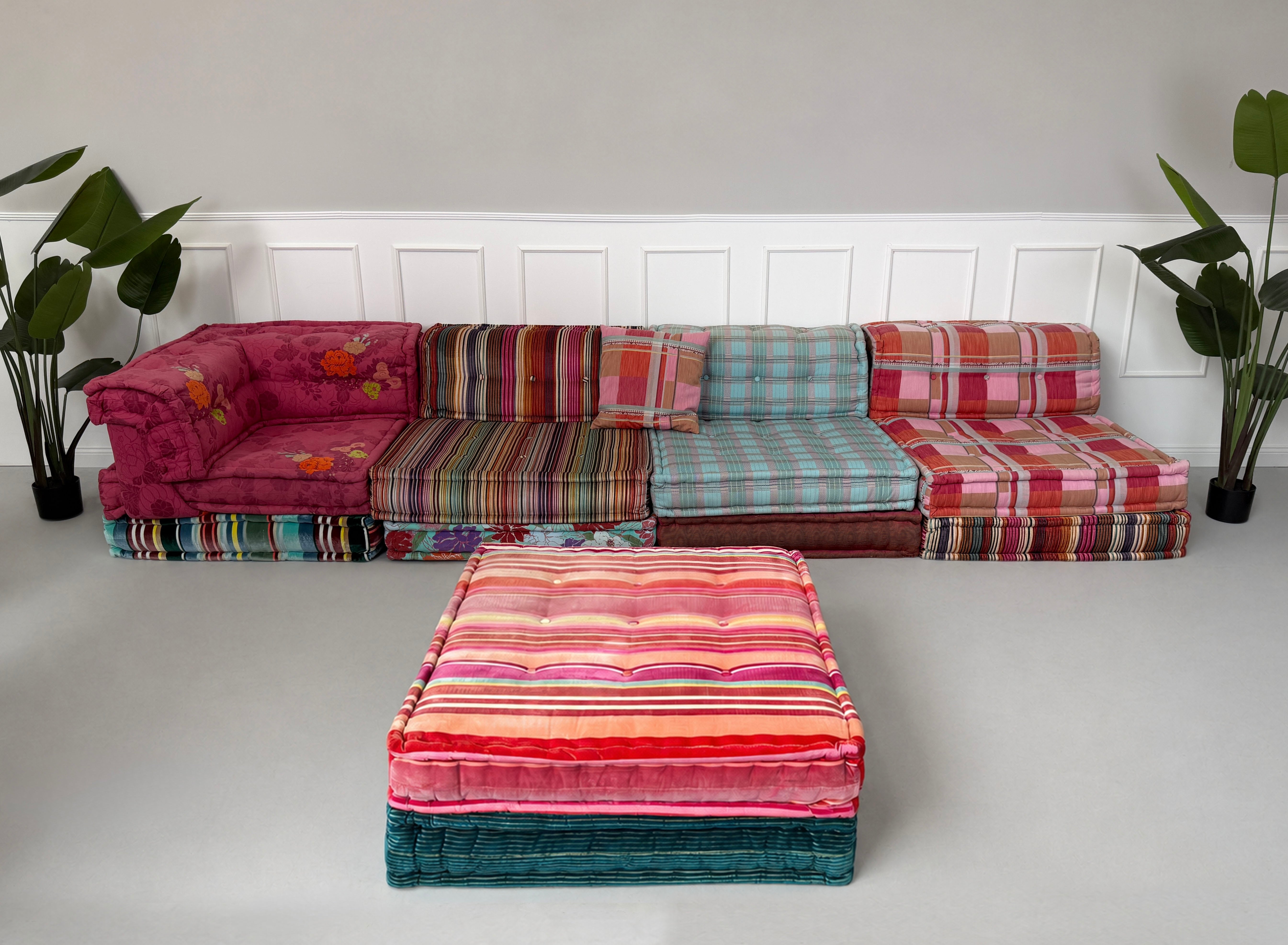 Gebrauchtes buntes Roche Bobois Mah Jong Designer Stoff Sofa vor einer Wand, stilvoll und modern eingerichtet.