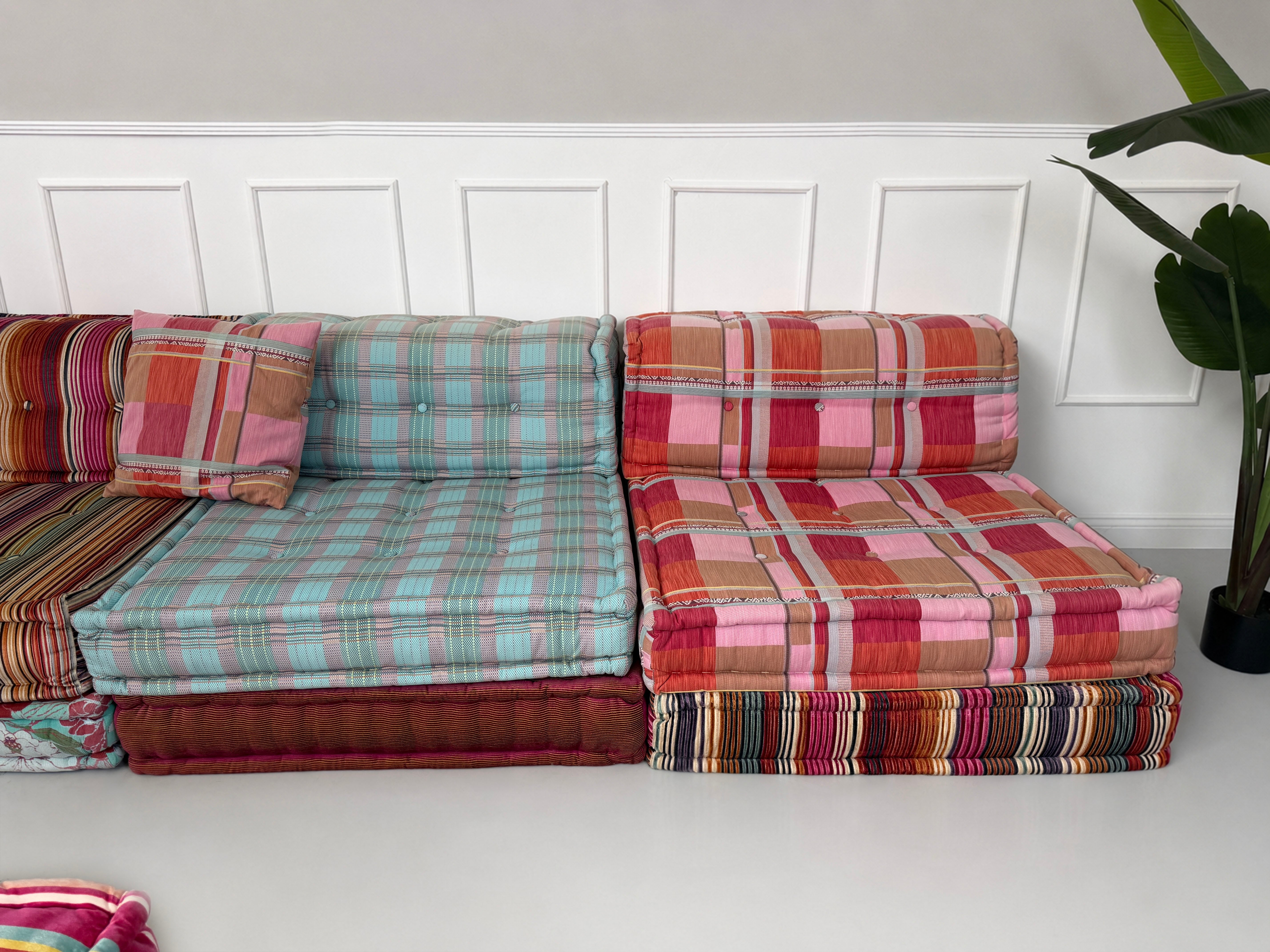 Gebrauchtes buntes Roche Bobois Mah Jong Designer Stoff Sofa vor einer Wand, stilvoll und modern eingerichtet.