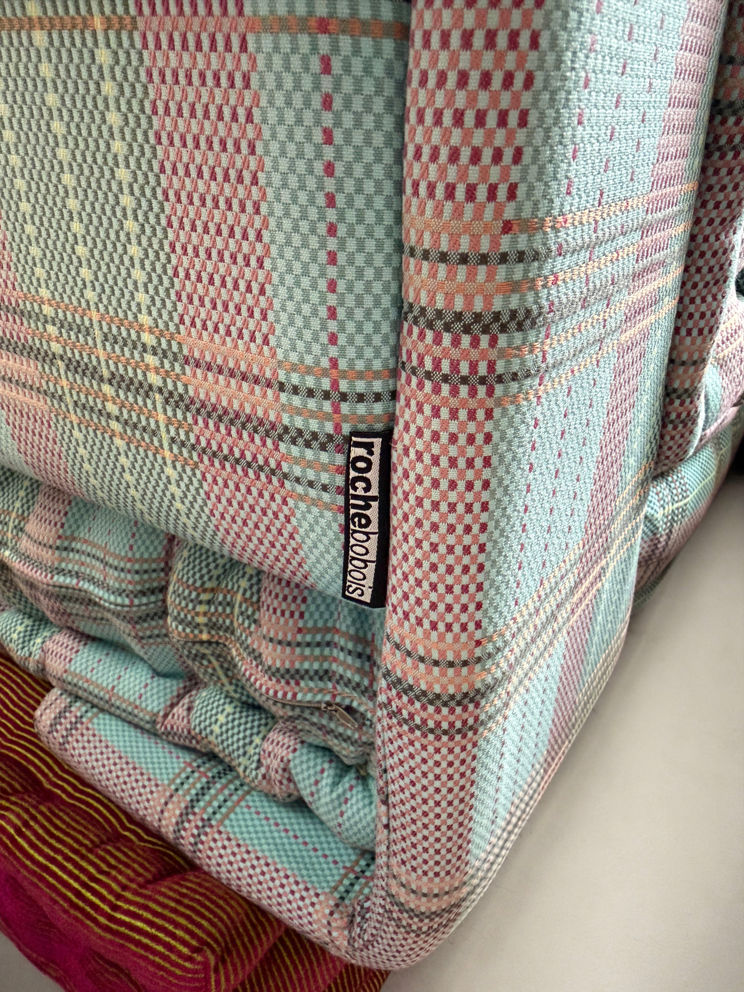 Gebrauchtes buntes Roche Bobois Mah Jong Designer Stoff Sofa vor einer Wand, stilvoll und modern eingerichtet.