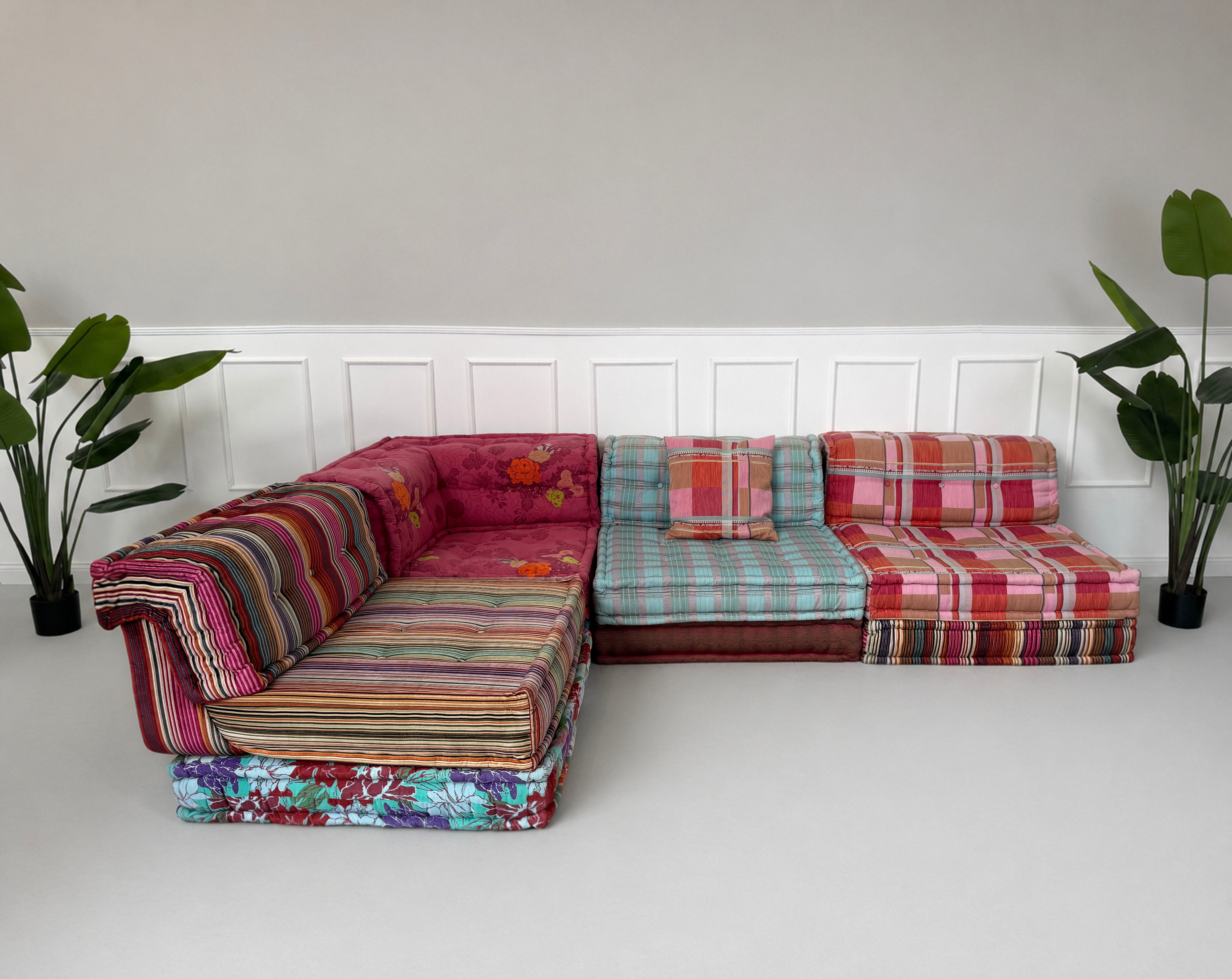 Gebrauchtes buntes Roche Bobois Mah Jong Designer Stoff Sofa vor einer Wand, stilvoll und modern eingerichtet.