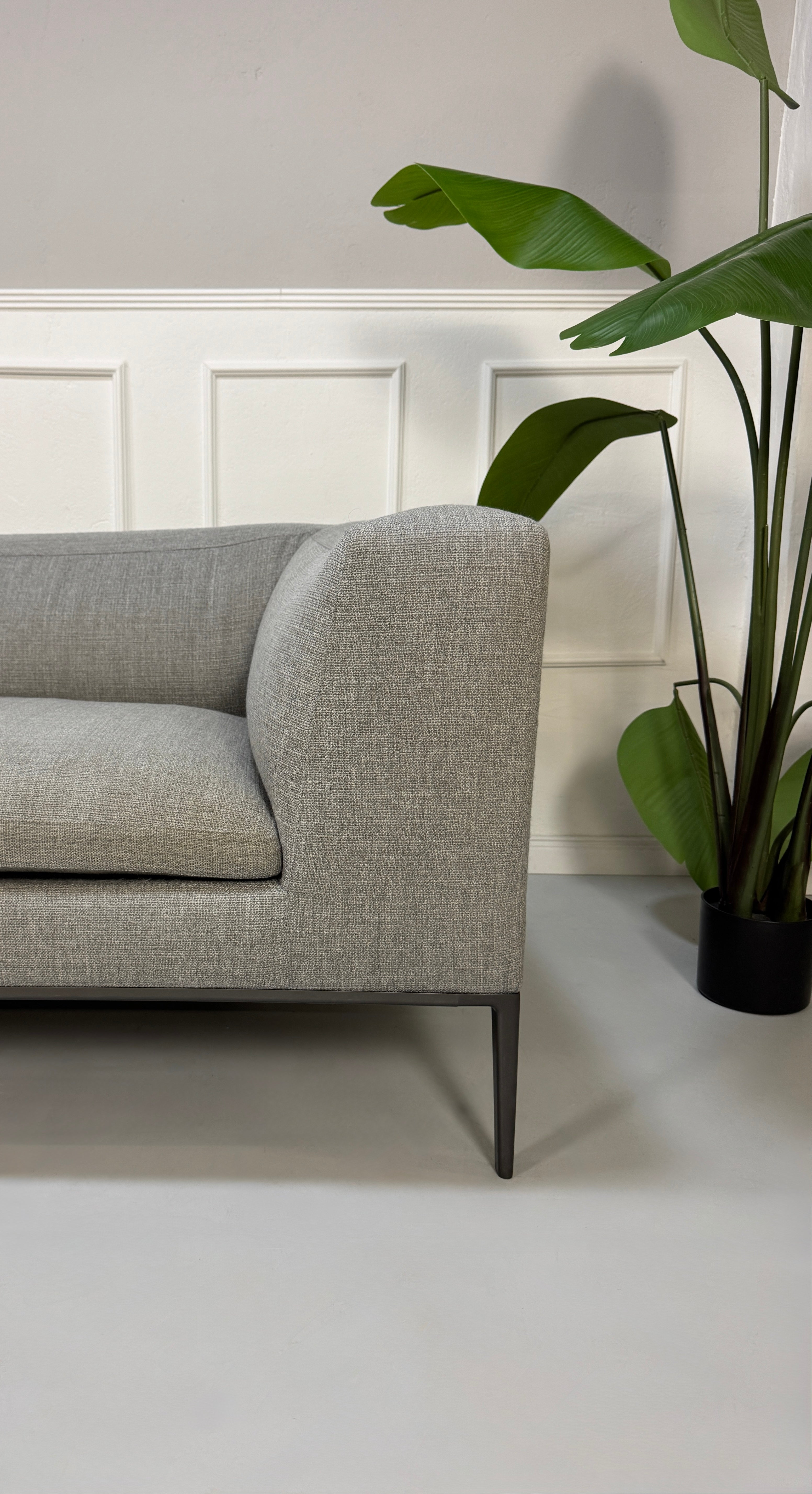 Gebrauchtes graues B&B Italia Michel  Designer Stoff Sofa vor einer Wand, stilvoll und modern eingerichtet.