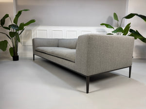 Gebrauchtes graues B&B Italia Michel  Designer Stoff Sofa vor einer Wand, stilvoll und modern eingerichtet.