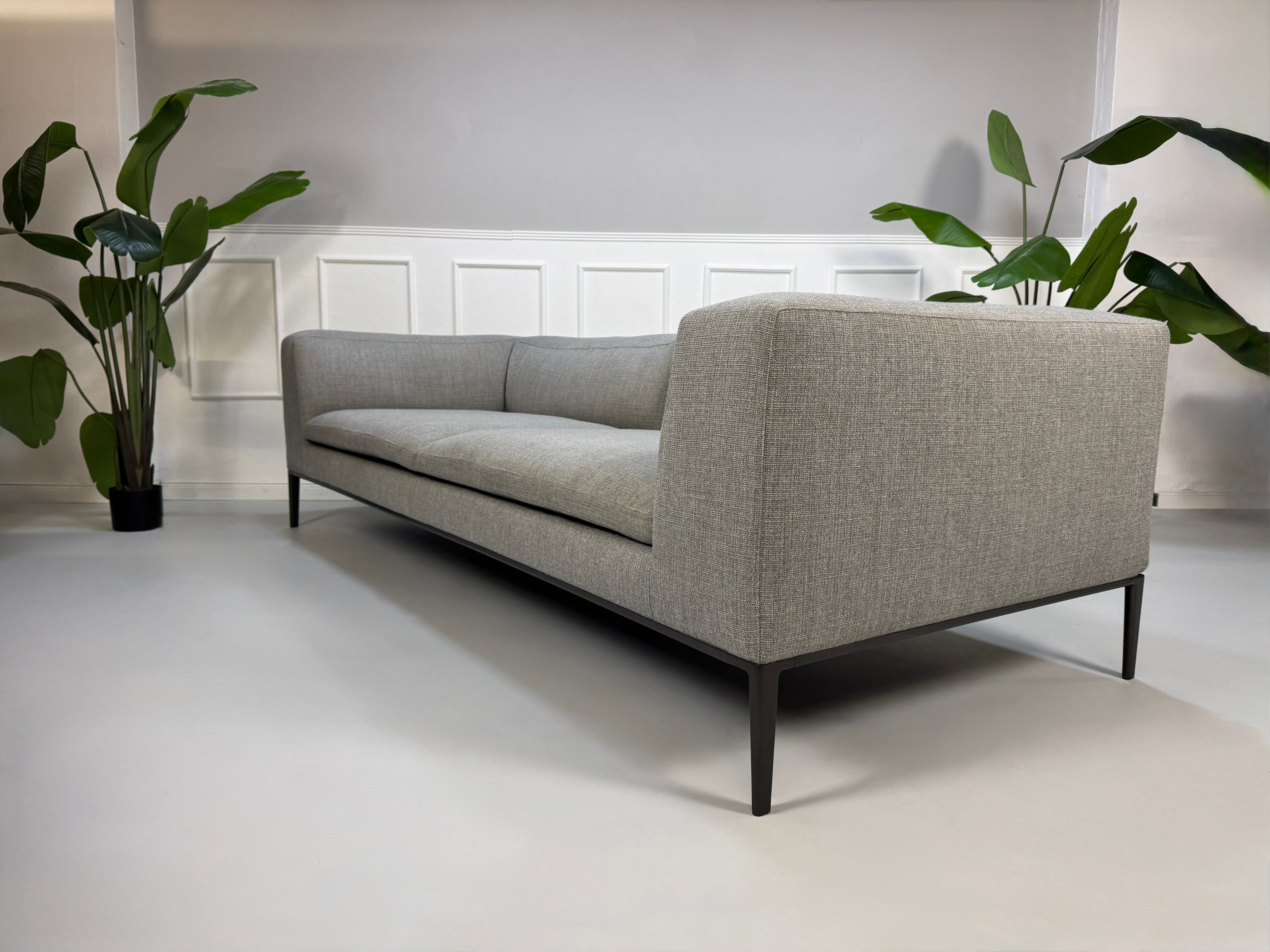 Gebrauchtes graues B&B Italia Michel  Designer Stoff Sofa vor einer Wand, stilvoll und modern eingerichtet.