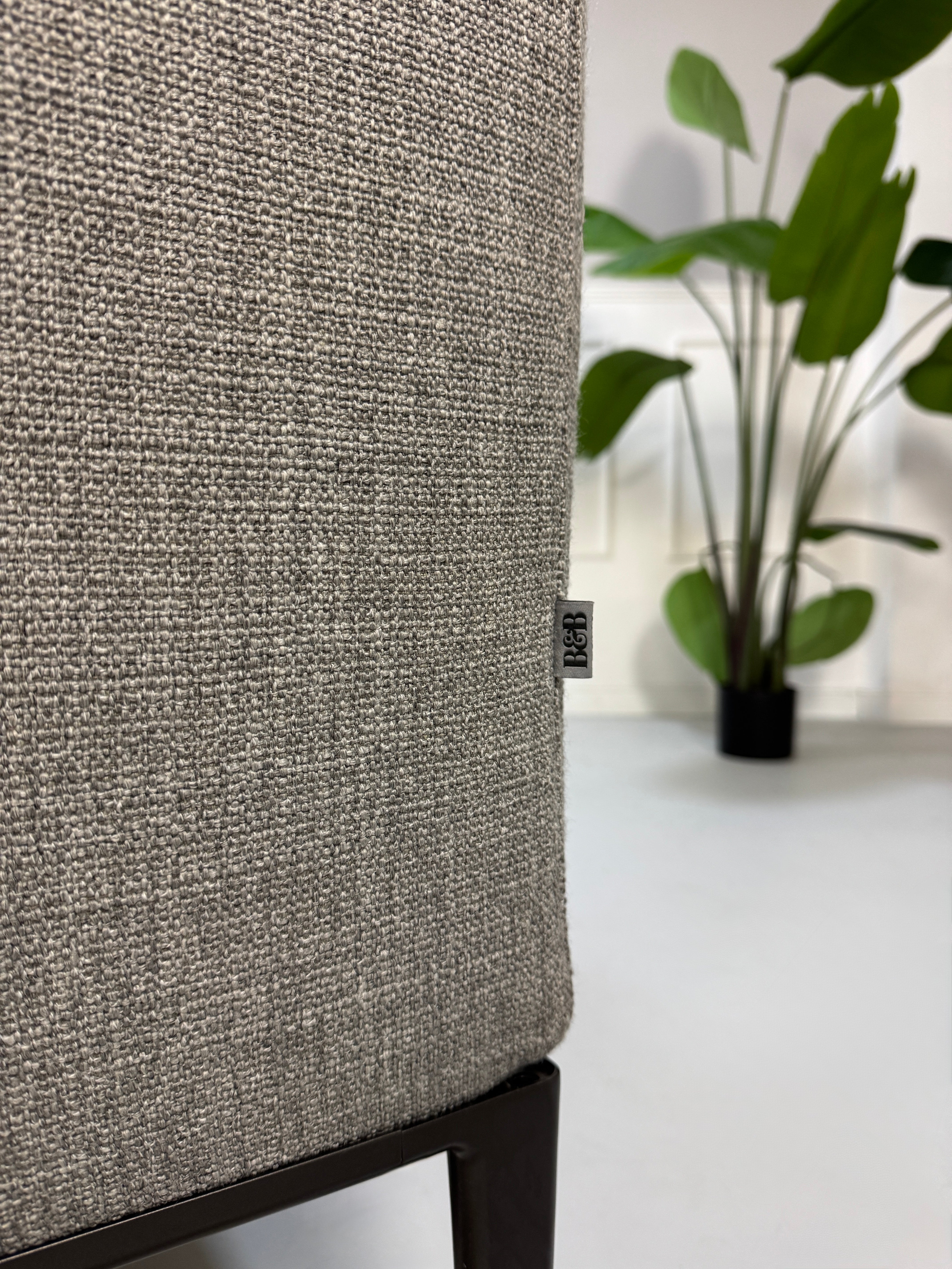 Gebrauchtes graues B&B Italia Michel  Designer Stoff Sofa vor einer Wand, stilvoll und modern eingerichtet.