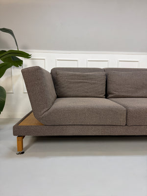 Gebrauchtes braunes Brühl Moule Designer Stoff Sofa vor einer Wand, stilvoll und modern eingerichtet.