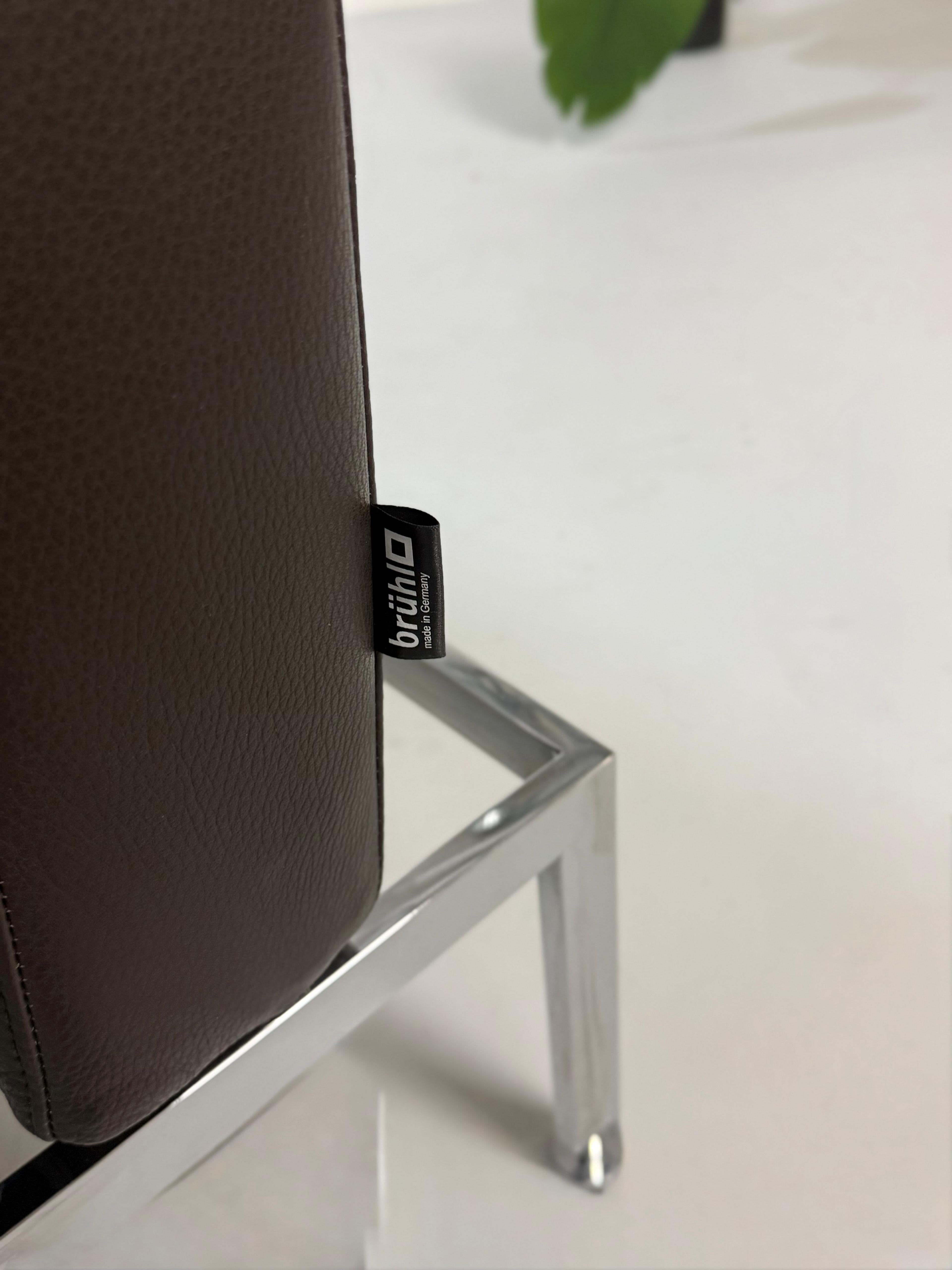 Gebrauchtes braunes Ledersofa Brühl Modell Roro Soft vor einer modernen Wand.