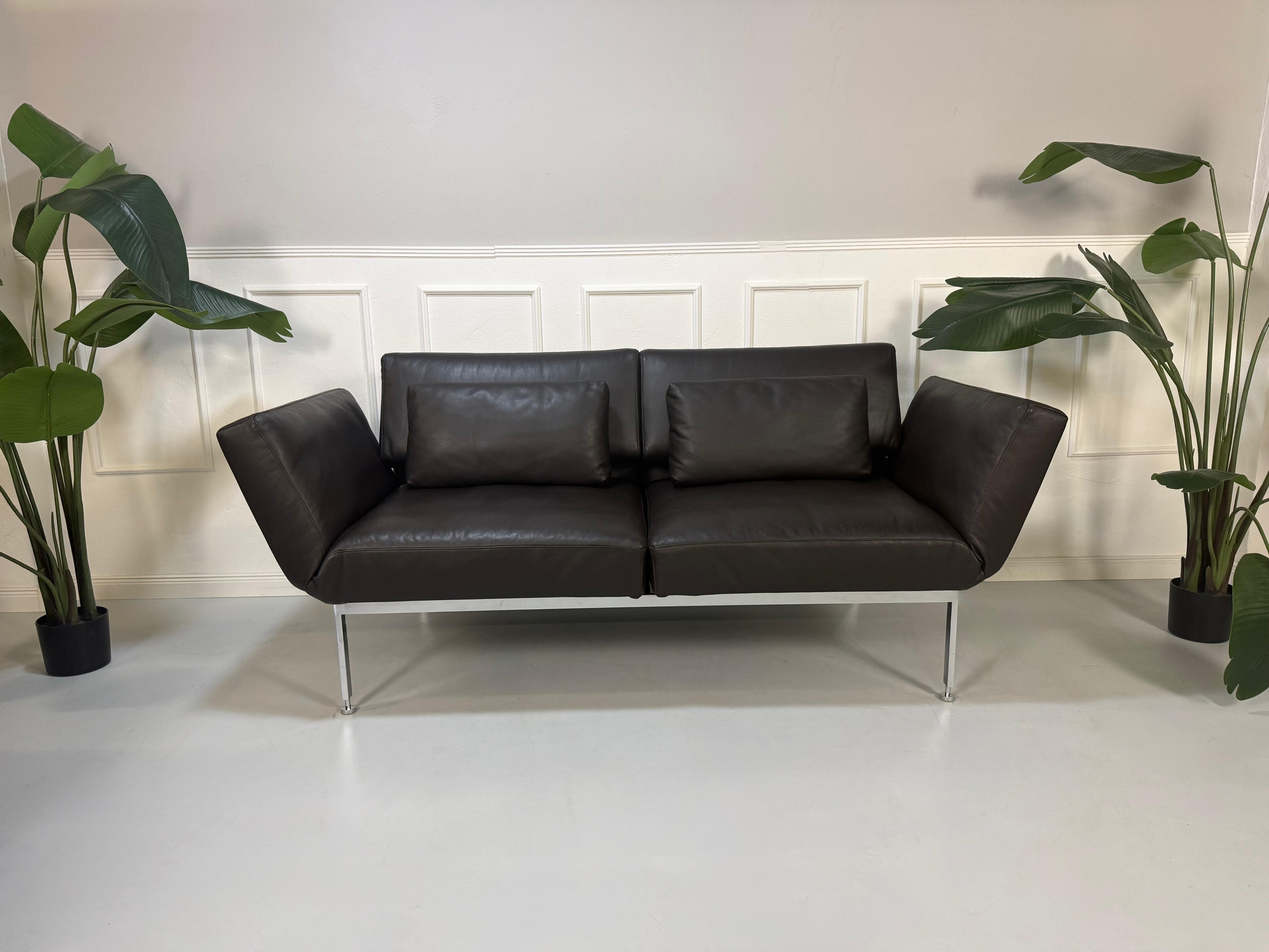 Gebrauchtes braunes Ledersofa Brühl Modell Roro Soft vor einer modernen Wand.