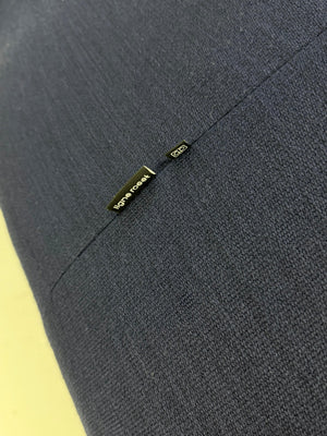 Gebrauchtes blaues Stoff Sofa Ligne Roset Pumpkin vor einer modernen Wand.