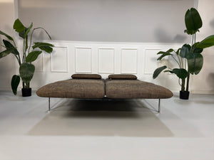 Gebrauchtes braunes Stoff Sofa Brühl Modell Roro vor einer modernen Wand.