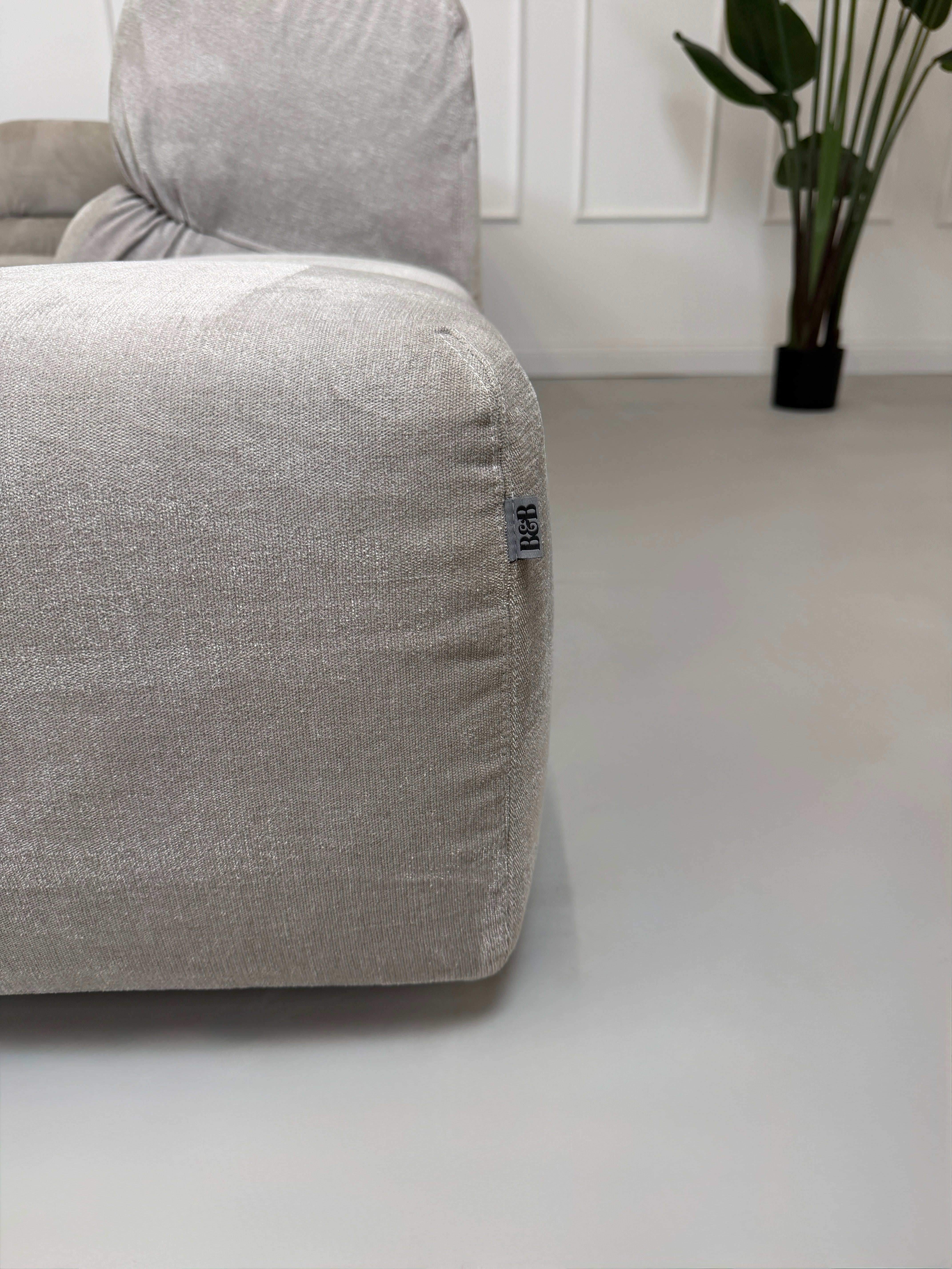 Refurbished graues B&B Italia Tufty Time Designer Stoff Sofa vor einer Wand, stilvoll und modern eingerichtet.