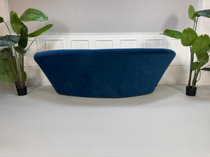 Gebrauchtes blaues Stoff Sofa Ligne Roset Modell Ploum vor einer modernen Wand.