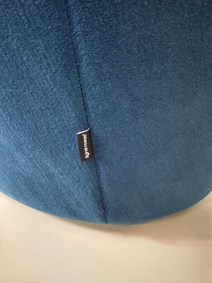 Gebrauchtes blaues Stoff Sofa Ligne Roset Modell Ploum vor einer modernen Wand.
