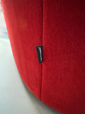 Gebrauchtes rotes Stoff Sofa Ligne Roset Modell Ploum vor einer modernen Wand.