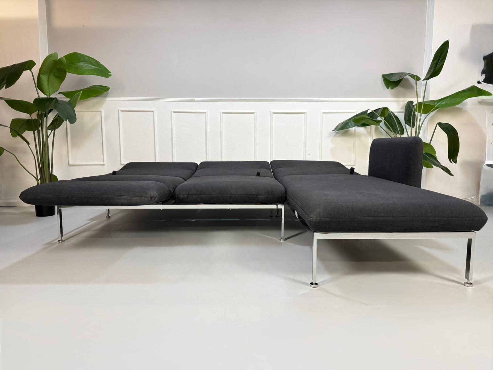 Gebrauchtes graues Brühl Roro Designer Stoff Sofa vor einer Wand, stilvoll und modern eingerichtet.