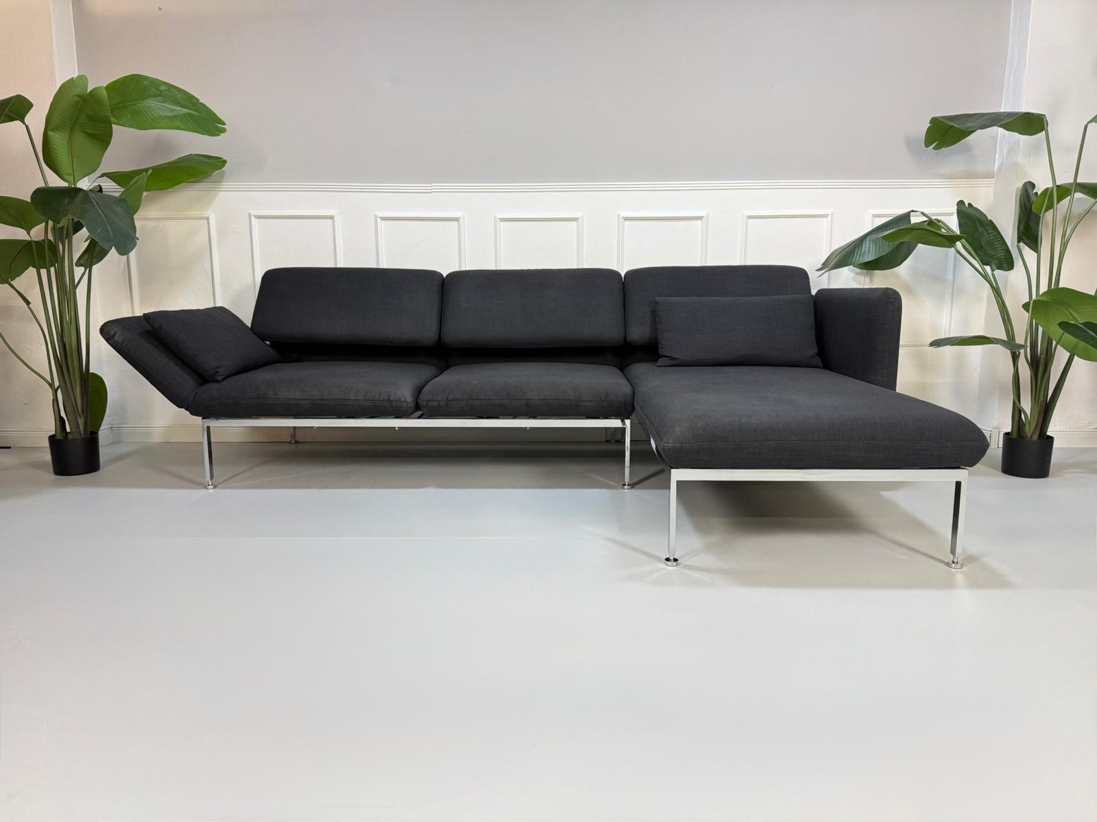 Gebrauchtes graues Brühl Roro Designer Stoff Sofa vor einer Wand, stilvoll und modern eingerichtet.