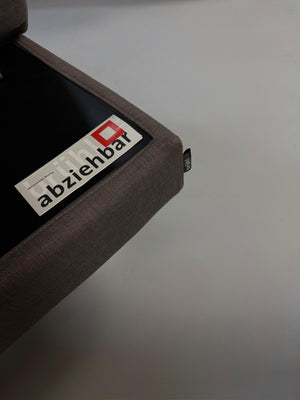 Gebrauchtes graues Brühl Four Two Designer Stoff Sofa vor einer Wand, stilvoll und modern eingerichtet.