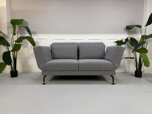 Gebrauchtes Brühl Moule Designer Stoff Sofa als Ausstellungsstück in der Farbe Grau vor einer Wand, stilvoll und modern eingerichtet.