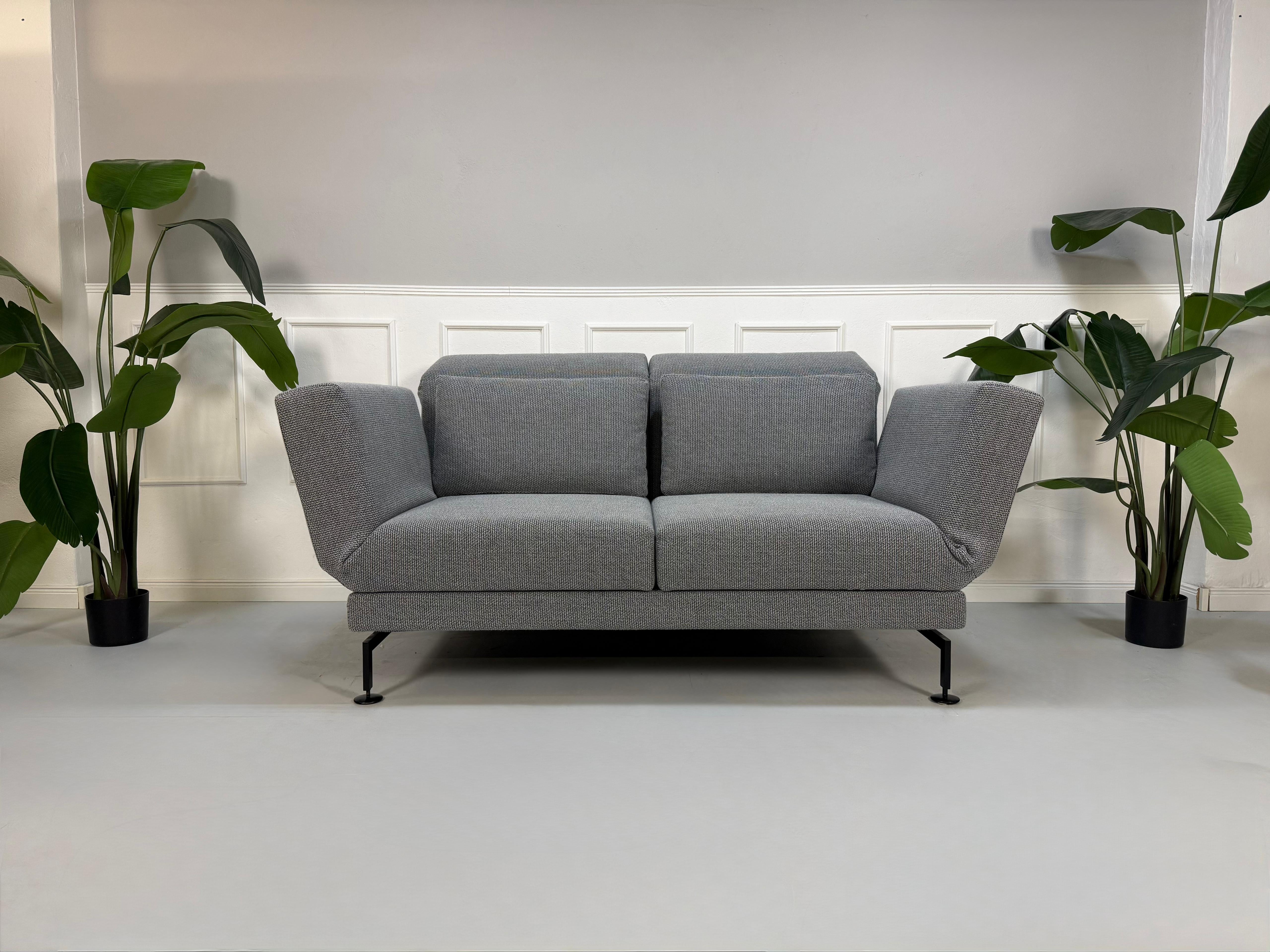 Gebrauchtes Brühl Moule Designer Stoff Sofa als Ausstellungsstück in der Farbe Grau vor einer Wand, stilvoll und modern eingerichtet.